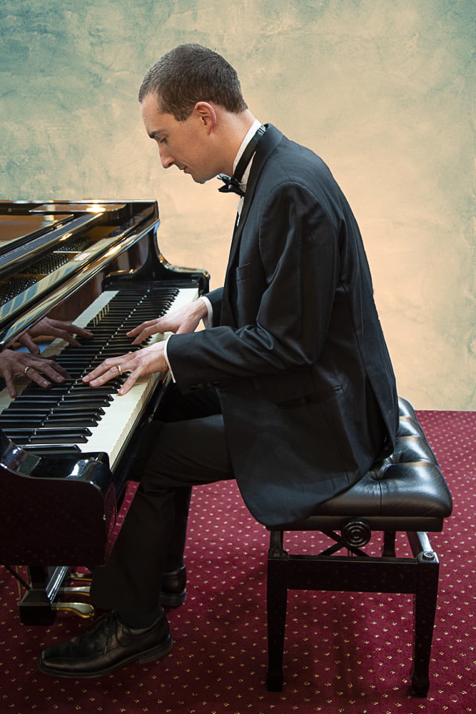 profile shot of John at the piano